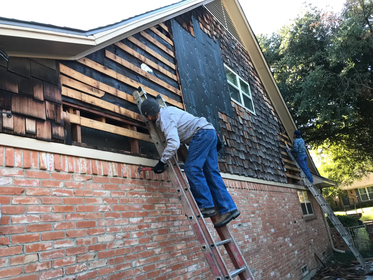 Tearing off old cedar shake siding on a gable wall in Dallas, TX