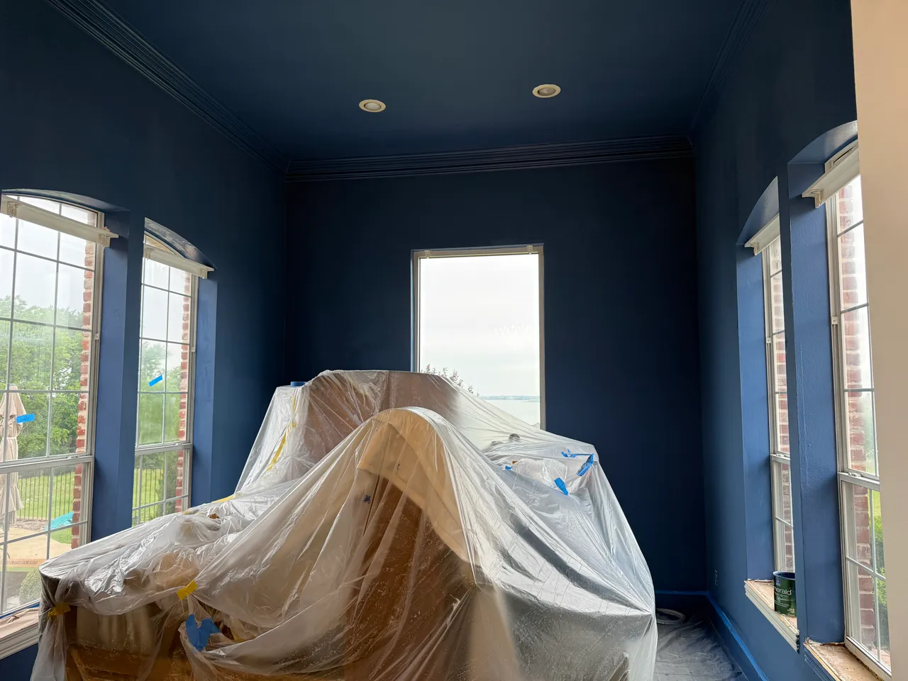 Living room walls and ceiling repainted navy blue in Rockwall, TX, with furniture protected during the job