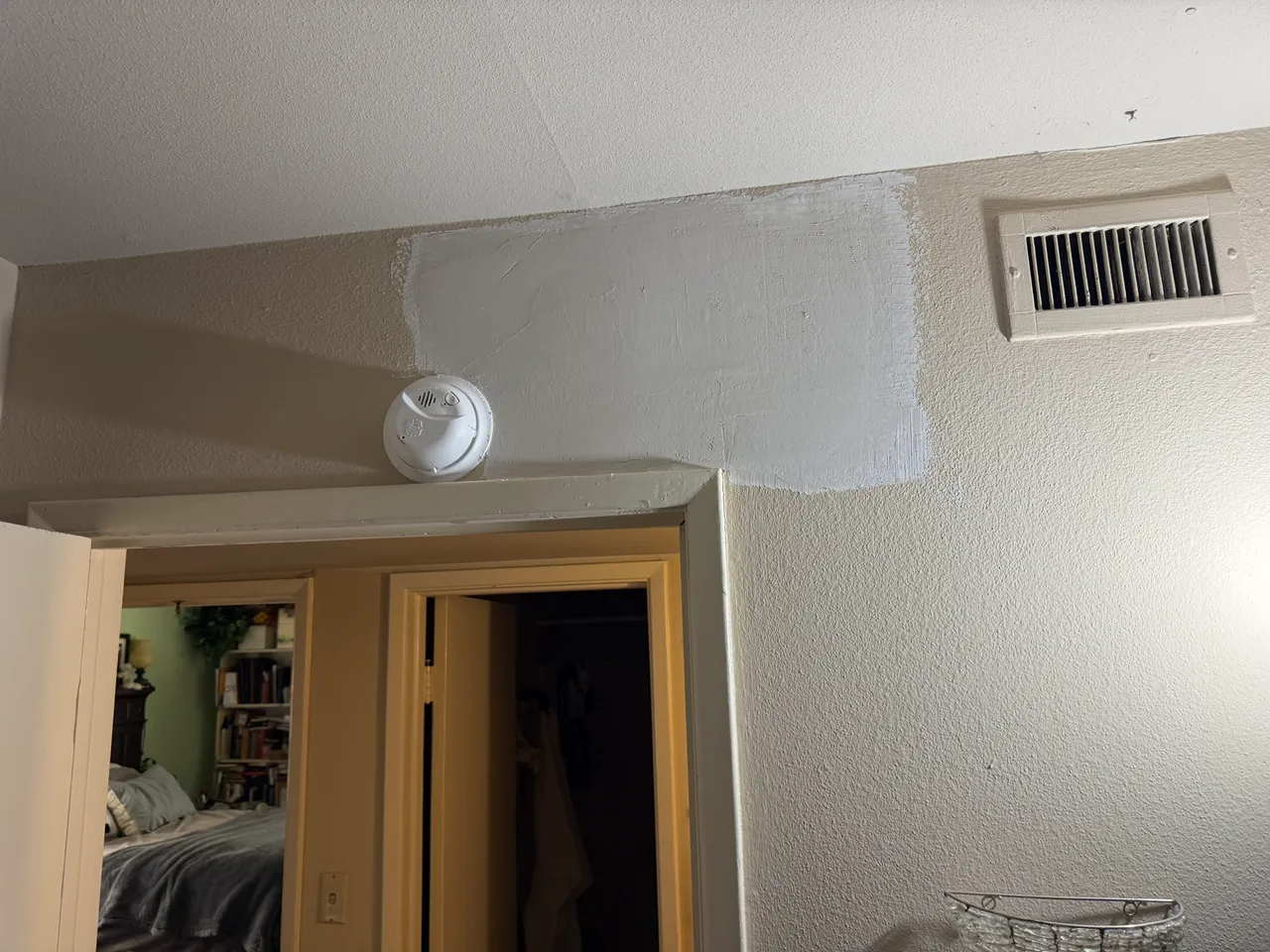 Wall crack above a doorway in Richardson, TX, patched with joint compound before texture and paint